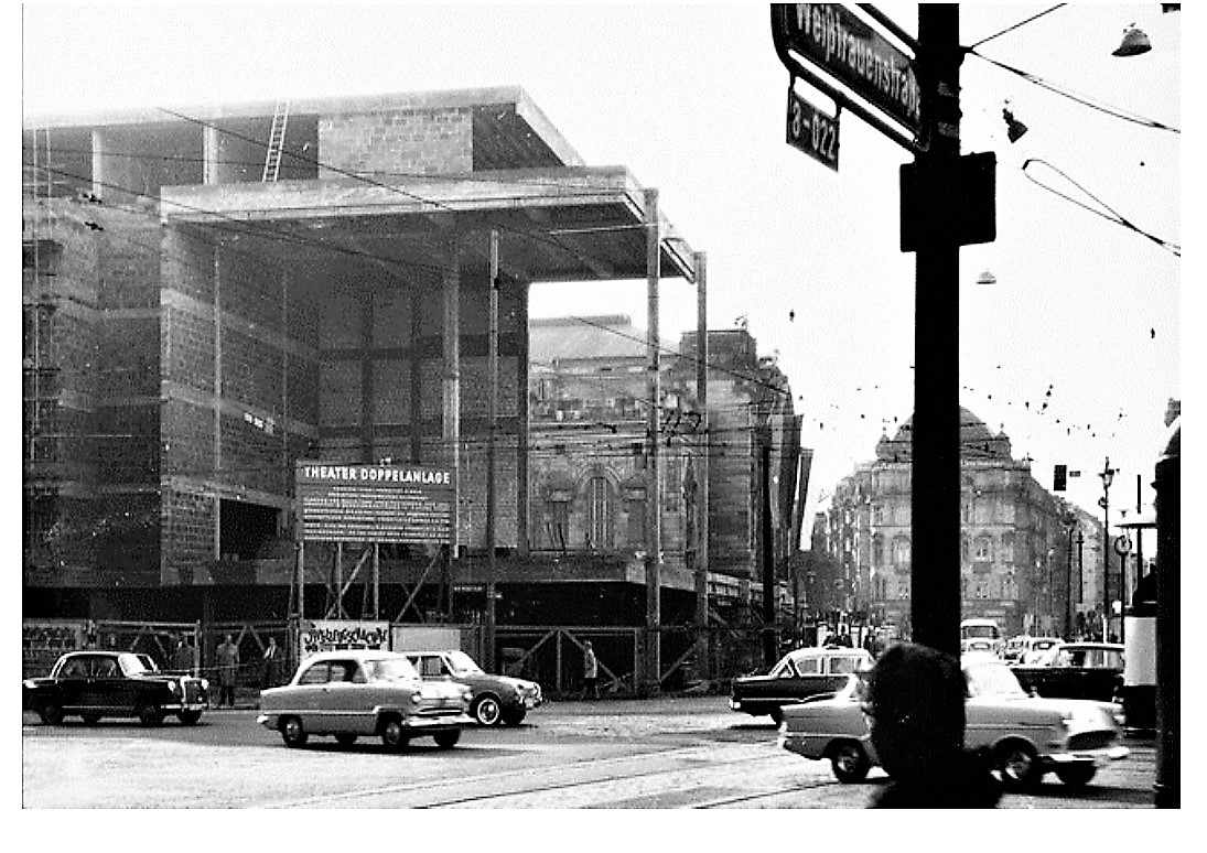   Theaterdoppelanlage und Schauspielhaus < > Auf dem Bild sieht man, wie Teile des original Schauspielhauses von 1902 mit den Glaswaenden der Doppelanlage umbaut werden. Im Hintergrund sieht man das Merceda-Haus, dass spaeter abgerissene und durch einen skurrilen, haesslichen braunen Neubau ersetzt wurde. PS: KEIN Gebaeude, nicht ein einziges auf dem damaligen Theaterplatz war zerbombt, lediglich die Daecher der Haeuser wurden durch die Druckwellen der, auf die Untermainbruecke gefallenen, Bomben zerstoert. < >